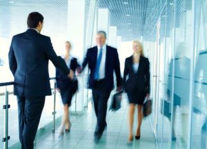 Business professionals shake hands in a modern office, demonstrating successful RTO consulting partnerships.
