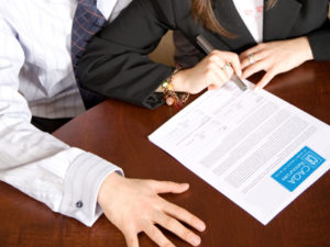 Business people finalize a contract, highlighting RTO compliance.