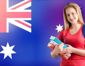 A young woman studies with books as the Australian flag waves, relating to changes in VET compliance.
