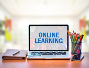 A laptop showing online learning resources with school supplies, highlighting the importance of accessible training.