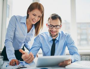 Business professionals review Skill First data on a tablet, highlighting RTO training needs.
