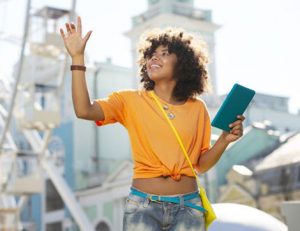 A woman uses a tablet at an amusement park, demonstrating how direct observations can be applied to online learning.