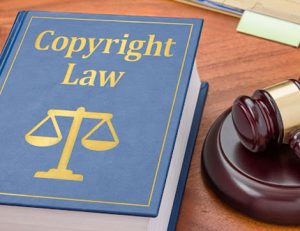 A law book and gavel illustrate copyright law and legal recourse for infringement.