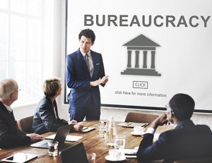 A business meeting illustrates the impact of bureaucracy on the education and training industry.