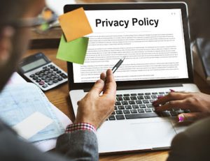 A laptop displays a privacy policy with office supplies, important for vet compliance.