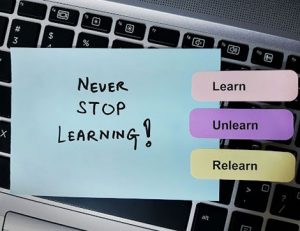 A laptop screen displays a message about lifelong learning, highlighting the importance of upskilling.