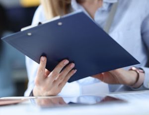 An office worker reviews documents on a clipboard, illustrating contextualisation in RTO training.