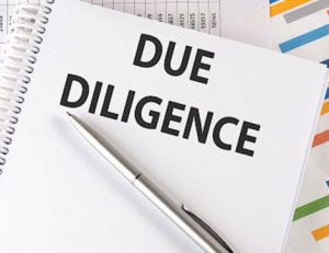 Due diligence paperwork and a pen represent the process of vet compliance.